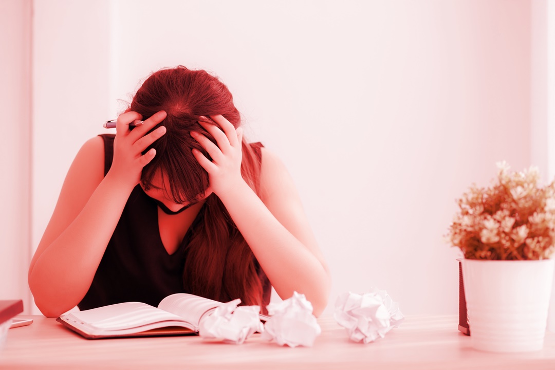 Escritora preocupada com o que está escrevendo no caderno